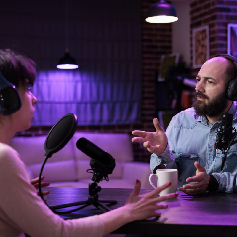 Man and woman creating podcast content online with equipment, recording social media discussion. Team of influencers talking about lifestyle and internet channel on live broadcast.